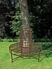 A circular metal bench around a tree trunk in a garden. Produktbild-Vorschau
