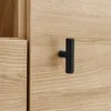A close-up shot of a wooden cabinet with a black T-shaped handle. Podgląd zdjęcia produktu