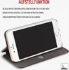 A white smartphone is shown in a dark gray flip case, propped up to demonstrate its stand function. Text describes the stand function. Produktbild-Vorschau