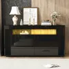 A black sideboard with LED lighting and drawers, decorated with a lamp, vase, and books. Anteprima dell’immagine prodotto