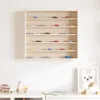 A wooden display shelf filled with miniature cars, mounted on a white wall above a white surface with wooden toys. Anteprima dell’immagine prodotto