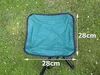 A green folding stool is placed on a grassy area. Voir les images du produit