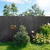 A garden scene with a fence, plants, and a small tree. Produktbild-Vorschau