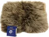 A close-up shot of a fluffy sheepskin seat cushion with a small blue tag in the bottom left corner. Podgląd zdjęcia produktu
