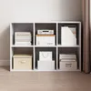A white cube bookshelf filled with various storage boxes and books. Produktbild-Vorschau