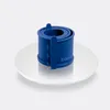 A blue springform pan sits on a white plate against a light gray background. Produktbild-Vorschau