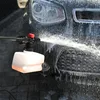 A pressure washer with a foam cannon attachment is spraying foam onto the front of a dark-colored car. Podgląd zdjęcia produktu