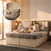 A couple is relaxing in bed in a bedroom, with a tray of food on the bed. Podgląd zdjęcia produktu