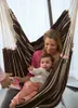A woman and a baby are sitting in a striped hammock chair. Produktbild-Vorschau