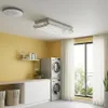 A laundry room with a stacked washer and dryer, a shelf with cleaning supplies, and a ceiling-mounted clothes dryer. Náhľad obrázku produktu