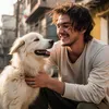 A young man is happily interacting with a white dog outdoors. Náhled obrázku produktu