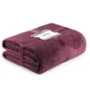 A folded quilted blanket with a geometric pattern, tied with a ribbon and a tag. Produktbild-Vorschau