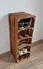 A wooden shoe rack made of crates, filled with various shoes, standing against a white wall. Produktbild-Vorschau
