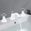 A white faucet with silver handles is installed in a white sink, with water flowing from the spout. Produktbild-Vorschau
