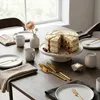 A cake and place settings on a wooden table. Anteprima dell’immagine prodotto