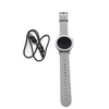 A smartwatch and its charging cable are laid out on a white background. Podgląd zdjęcia produktu