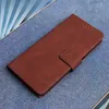 A brown leather phone case is shown on a blue textured surface, with a blue and white striped object in the background. Produktbild-Vorschau