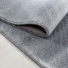 A close-up view of a gray carpet with a textured pattern, showing the edge and underside. Produktbild-Vorschau