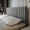 A close-up view of a bed with a tufted headboard and white pillows. Produktbild-Vorschau