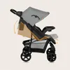 A side view of a gray and black baby stroller, with orange lines and arrows indicating adjustable features. Podgląd zdjęcia produktu