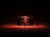 A gaming monitor displaying a fiery, robotic image, set against a dark background with red atmospheric lighting. Produktbild-Vorschau