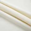 A close-up shot of folded cream-colored velvet fabric, showing the texture and folds. Náhled obrázku produktu