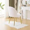 A white fluffy chair with gold legs sits on a white rug in front of a vanity table and a large mirror. Podgląd zdjęcia produktu