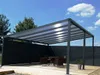 An outdoor patio area with a modern pergola, dining set, and fence. Voir les images du produit