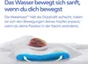 A pillow with a water-filled base is shown with a baby's head resting on it, illustrating the product's support feature. Produktbild-Vorschau