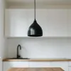 A black pendant light hangs in a modern kitchen setting. Náhled obrázku produktu