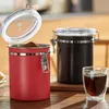 Two coffee canisters and a glass of coffee on a wooden table. Produktbild-Vorschau