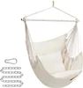 A cream-colored hammock chair with two cushions, suspended by ropes from a white bar. A metal carabiner and chain are shown to the left. Náhled obrázku produktu