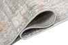 A close-up, rolled corner view of a modern rug with a distressed pattern in gray, blue, and orange tones. Anteprima dell’immagine prodotto