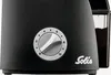 Close-up of a black coffee grinder with a silver dial and a container of coffee grounds. Podgląd zdjęcia produktu