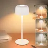 A white LED table lamp is displayed on a wooden desk next to a stack of books, with a warm light emanating from it. The image also includes smaller inset images of the lamp in different settings. Produktbild-Vorschau