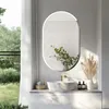 A modern bathroom vanity with a sink and mirror, decorated with plants and soap dispensers, with a window view of greenery. Podgląd zdjęcia produktu