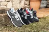 Several pairs of Dunlop sneakers are displayed outdoors on grass and stone steps. Produktbild-Vorschau