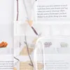 A close-up of a sheer curtain with a floral and leaf pattern, showing some text printed on what appears to be a magazine or book in the background, and a drawstring mechanism for adjusting the curtain. Produktbild-Vorschau