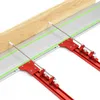 A close-up view of a wooden plank resting on a metal guide rail system with red clamps. Náhled obrázku produktu