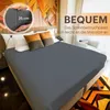 A bed with a fitted sheet and pillows, with text overlays highlighting product features. Produktbild-Vorschau