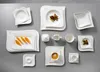 A collection of white ceramic tableware arranged on a gray surface. Anteprima dell’immagine prodotto