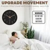 A woman sleeping in a bed next to a wall clock. Produktbild-Vorschau