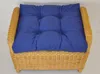 A blue cushion on a wicker ottoman. Produktbild-Vorschau