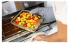 A person is taking a glass container filled with cooked vegetables out of an oven. Náhľad obrázku produktu