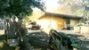 A first-person perspective of a video game scene, showing a weapon aiming at a tank in front of a building. Produktbild-Vorschau