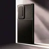 A black smartphone case is displayed on a shelf with dramatic lighting. Podgląd zdjęcia produktu