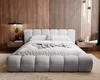 A modern bedroom with a large upholstered bed, wooden wall paneling, and minimalist decor. Náhled obrázku produktu