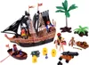 A pirate ship playset with various accessories, including figures, a cannon, barrels, and palm trees, arranged on a white background. Produktbild-Vorschau