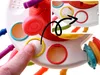 A finger is pressing a button on a colorful sensory toy. Náhľad obrázku produktu