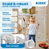 A child and a dog are separated by a baby gate in a home setting, with marketing text highlighting the gate's features. Produktbild-Vorschau